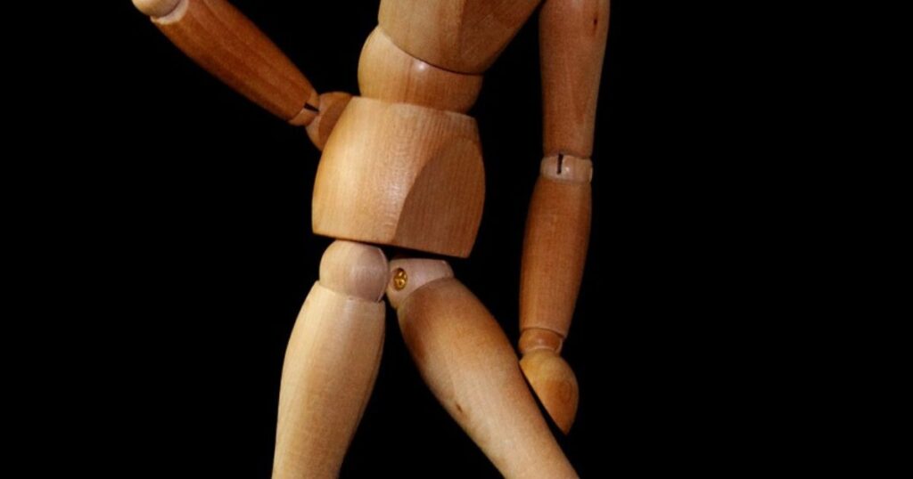 Wooden manikin demonstrating lower back pain