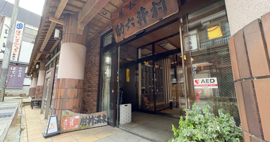山形県肘折温泉「若松屋村井六助温泉」の正面玄関と街並み。日帰り温泉利用者向けの入り口を写した写真。