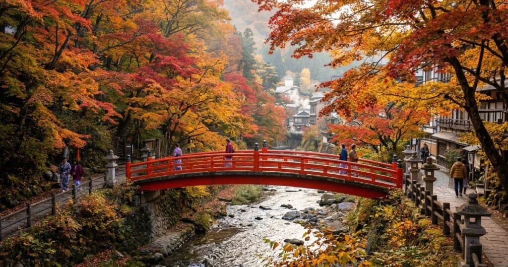 伊香保温泉の河鹿橋。鮮やかに色づいた紅葉に囲まれた赤い太鼓橋と、その下を流れる清流の風景。